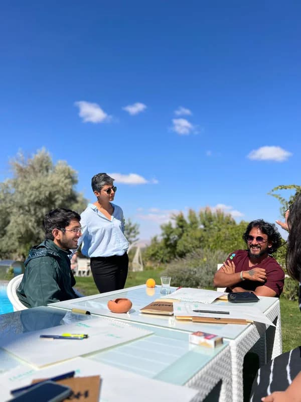 Travellers and a host gather around an outdoor table during a Bucketlist edition.